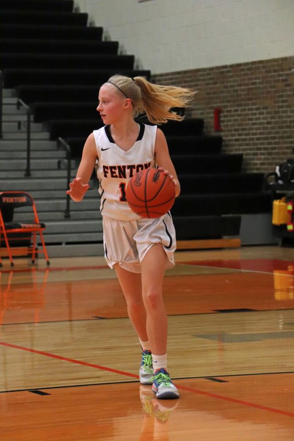 After receiving the ball, freshman Isabella MacCaughan dribbles the basketball up the court in the JV girls basketball game on Jan. 4. The Fenton Tigers lost to the Goodrich Martians 15-21.
