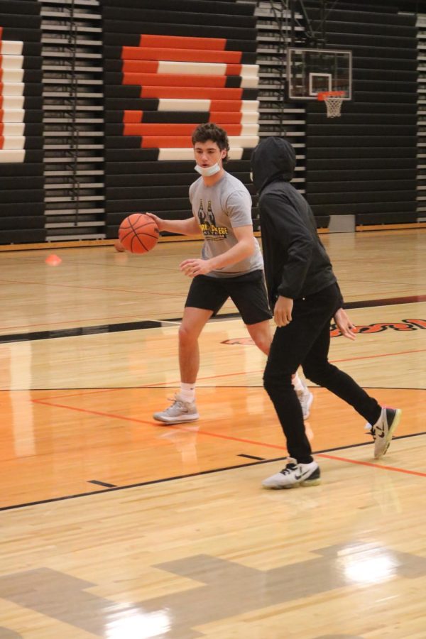 Senior Henri Sturm dribbles trying to get past his opponent Ayden Bowe. On Dec. 9 in gym teacher Chad Logans class the boys played a 1v1 basketball game. 