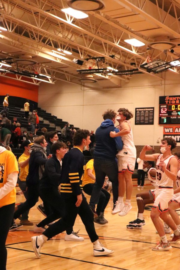 After+their+game%2C+the+boys+varsity+basketball+team+celebrates+with+their+classmates+and+friends+after+a+win+against+Swartz+Creek.+On+Dec.+10%2C+the+Tigers+defeated+the+Dragons+62-43.