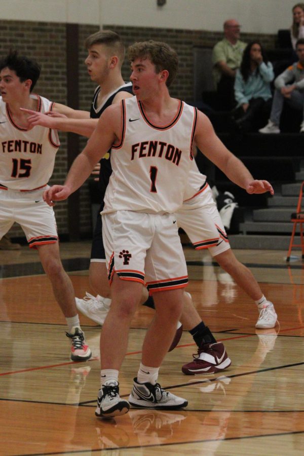 Playing defense, senior Connor Luck helps his team to prevent the opposing team from making a basket. The Fenton Tigers boys varisty basketball team played against Goodrich on Jan. 4 and won 59-49. 