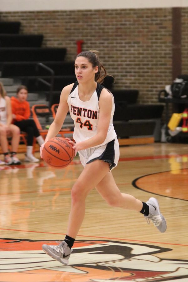Going for the basket, junior Maddison Slezinski dribbles the ball down the court in attempt to score for the Tigers. The Fenton Girls varsity team played against Kearsley on Jan. 7, and won 50-30. 
