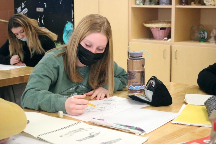 Sketching, freshman Emersyn Sprague works on her self portrait. On Jan. 21, the art foundations students drew their self portraits with their favorite sport. 