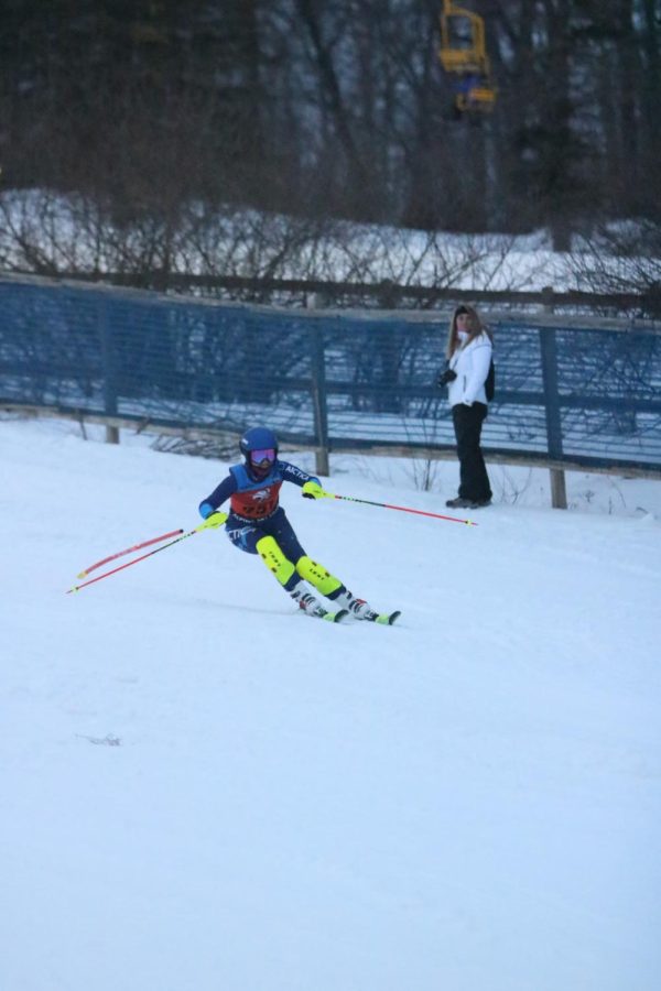 Turning around the gate, freshman Anna Heimberger skis down towards the finish line. On Feb. 9, the girls Alpine ski team was ahead by 3 points at the end of the first day of Divisionals. 
