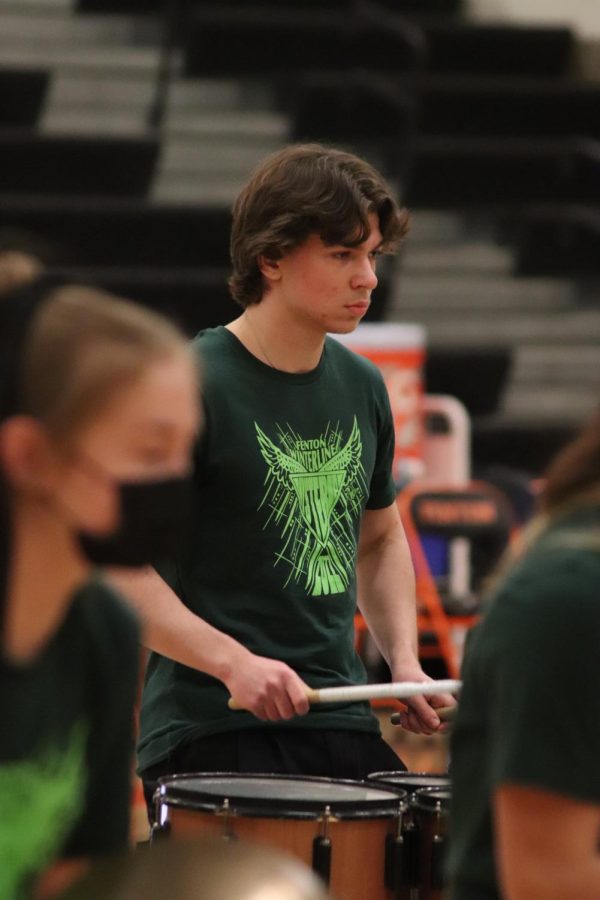 Playing the drums, sophomore David Verna performs with the FHS Winter Drumline during halftime at the girls varsity basketball game. On Feb. 4, the Fenton girls varsity basketball team played against Holly and won 39-23.