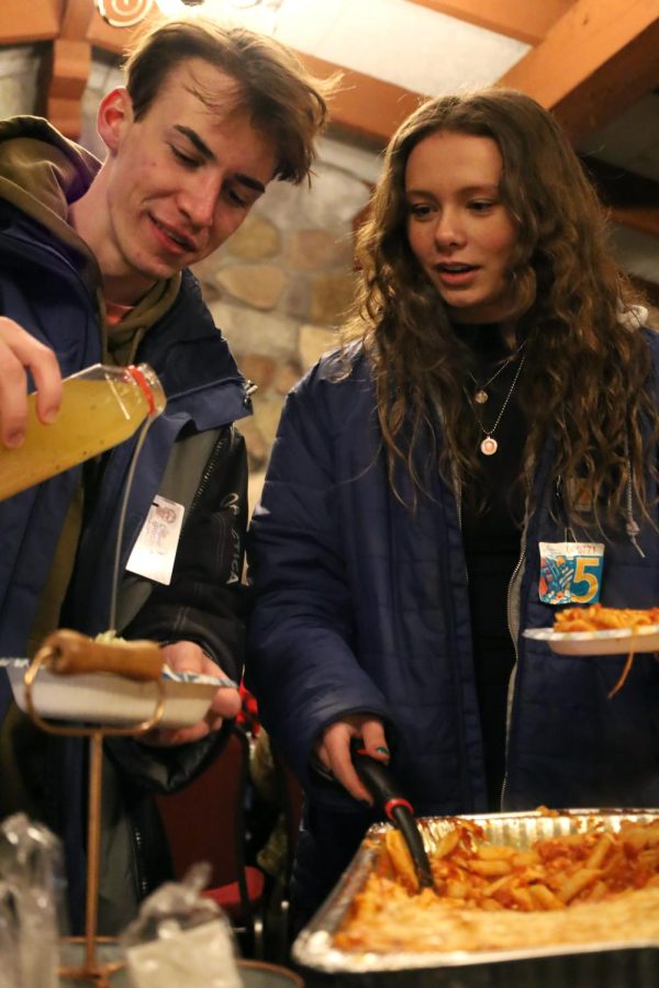 Joining their teammates, senior Chase Gibson and junior Jamie Kemp gather their plates for a team dinner while waiting for awards at their divisional championship race. On Feb. 10, both of the boys and girls varsity Alpine ski teams placed first in their division at Mt. Holly Ski & Snowboard Resort. 
