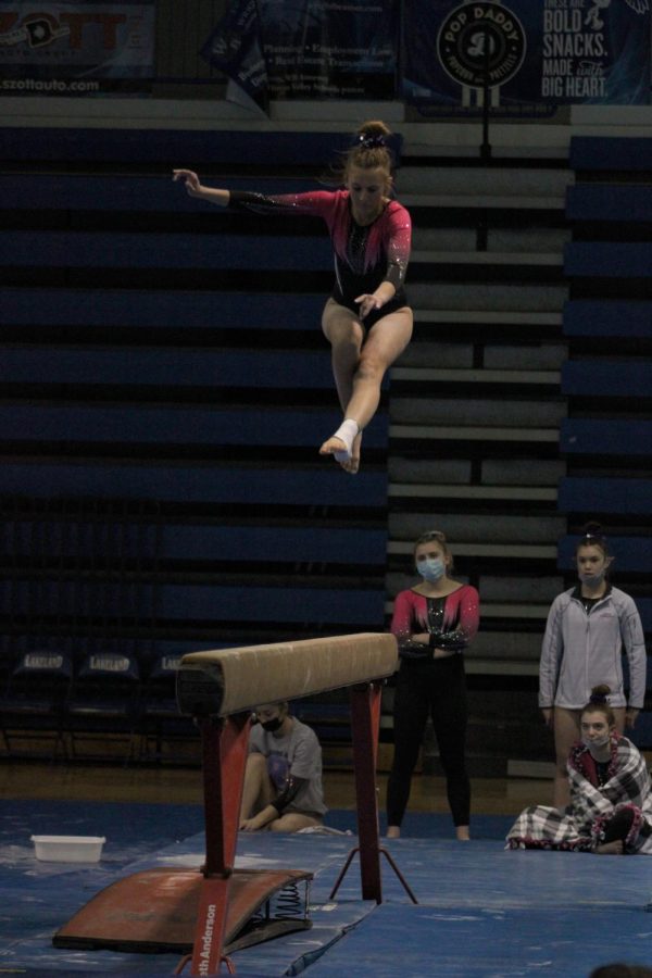 Senior+Maty+Temrowski+competes+on+beam+as+her+teammates+watch.+On+Jan.+29%2C+the+LFLF+gymnastics+team+took+12th+place+in+the+Jeanne+Carruss+Invitational+meet+at+Lakeland+High+School.
