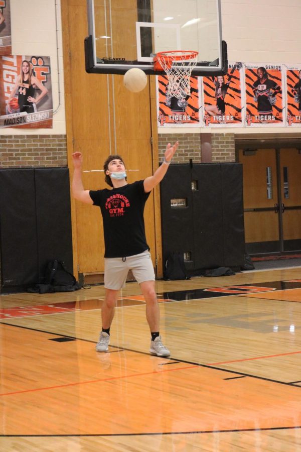 Senior Henri Sturm serves the ball to the opposing team. In Fenton High teacher Chad Logans Advanced Physical Education class on Feb. 7, the students participated in a volleyball tournament during free time. 