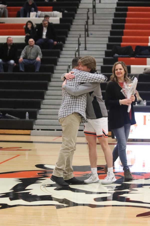 Hugging his dad, senior Austin Pedlar is honored on senior night. On March 3, the boys varsity basketball team showed their appreciation for this years seniors at their final regular season game. 