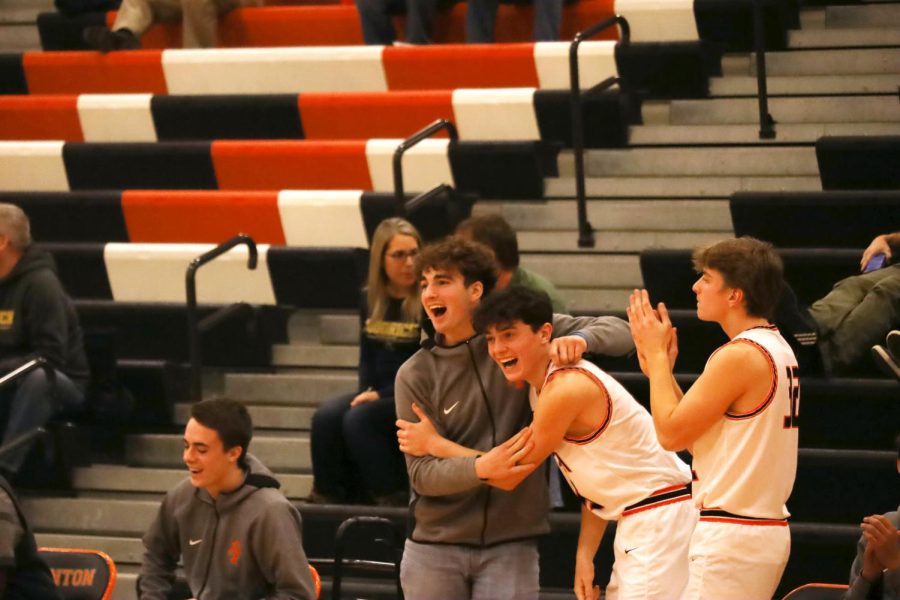 Seniors Calvin Curtis and Samuel Claborn celebrate a point made by teammate sophomore Samuel Dillard. The Tigers defeated Goodrich 59-49 on Jan. 4.