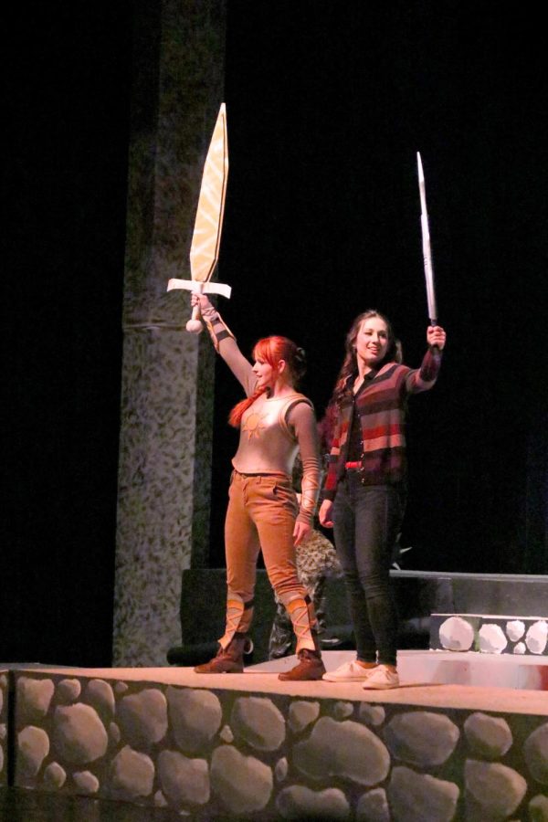 Raising their swords, senior Skye Hodgkin stands next to junior Maddie Burnau. On March 18, the FHS IB Theatre class performed She Kills Monsters to a group of students before opening night. 