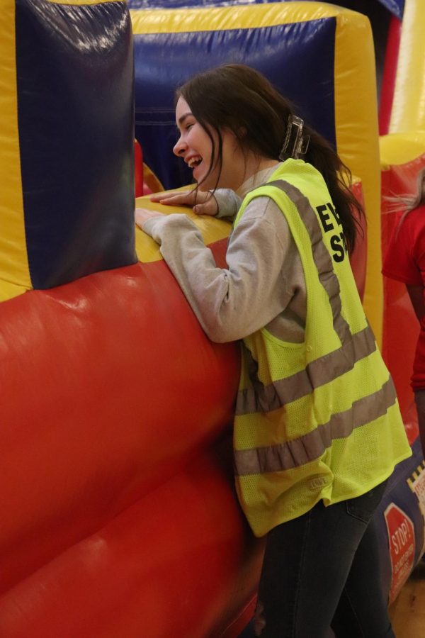 Junior Haley OBrian laughs as she leans over the edge of the bounce house to monitor the children playing inside. On March 5, the annual Fenton Expo was held at FHS. 