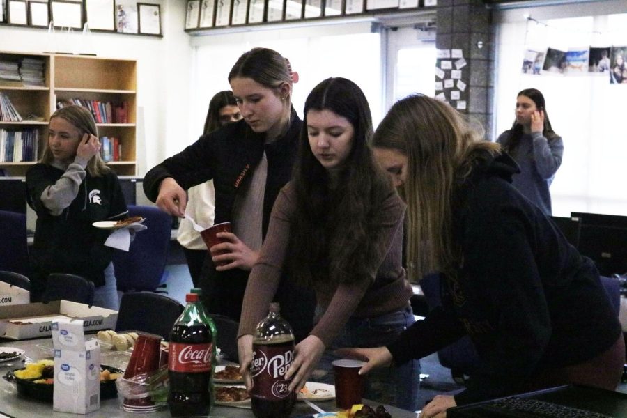 Senior Brianna Soule grabs food and drinks alongside sophomore Lily Turkowski and senior Meghan Maier. On March 23, the Fenton Advanced Desktop class has a party to celebrate recent accomplishments.