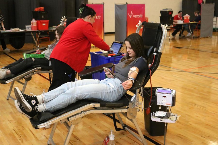 Looking at her phone sophomore Emily Cryderman gets her blood drawn. The National Honor Society held a blood drive at Fenton Senior High on April 28.