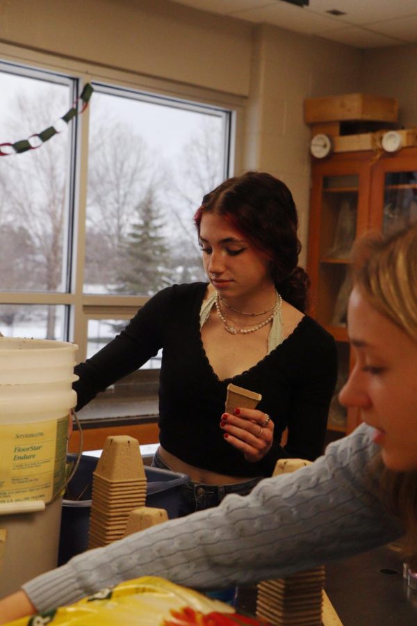Joining the ECO club, junior Emma Dubie fills her pot with soil. To celebrate Earth Day, physical science teacher Nicholaus Jeffrey invited students to plant seeds during SRT on April 19.