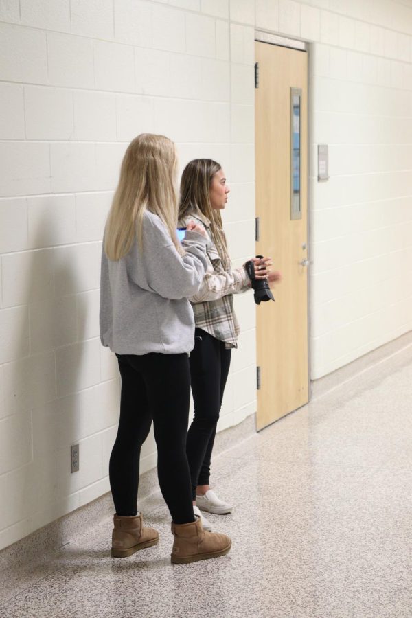 Sophomores Cassandra Tatton and Jillian Shanahan discuss the next video scene with their group out in the hallway. The Video Production 1 students worked in groups to film a silent-short film at FHS on April 7. 