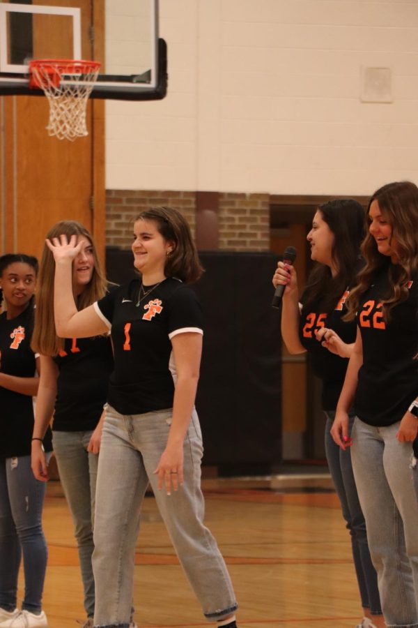 Varsity girl soccer player junior Abby Logan waves to the crowd, as she is introduced by senior captian Macy Melero. On March 22, the school puts on a ceremony for all the spring athletes. 
