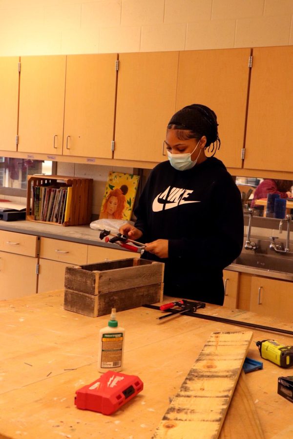 Preparing to cut wood, junior Kennedy Hamilton adjusts her bow saw. On April 8, Dave Sturms Woodshop class worked on individual projects creating boxes. 