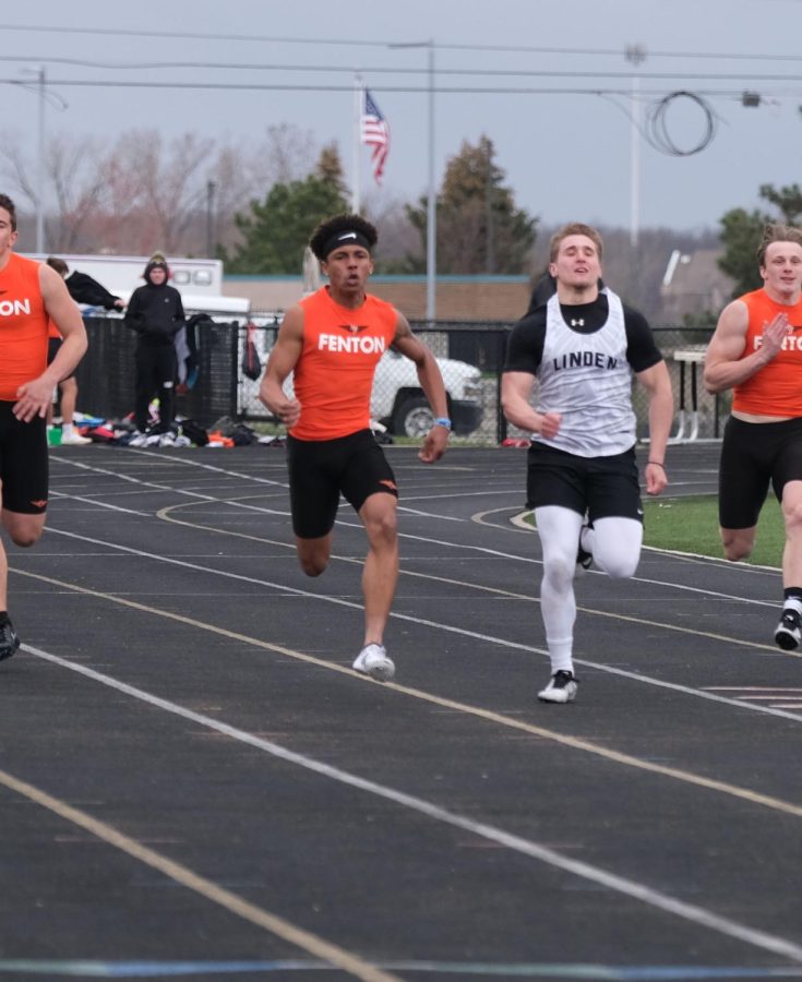 Running beside an opponent, senior Donovan Miller compets in the 100-meter dash. Miller took second with a time of 11.74 overall and the Tigers took first over Linden.  