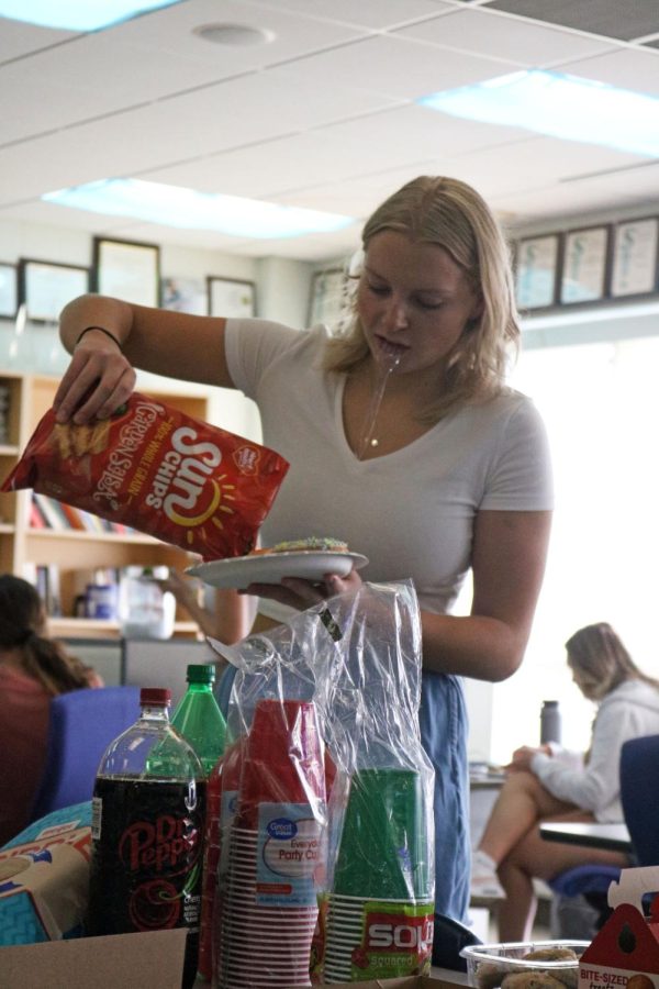 Grabbing food, senior Lizzy Wakeham celebrates the end of the 2021-2022 school year. On May 11, students in the Advanced Publications class held a party for the seniors last day. 