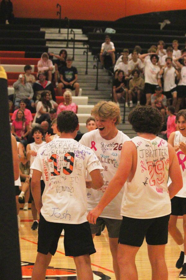 Smiling, senior Leo Thompson celebrates with his teammates. On Sept. 20, the volleyball program played the soccer program in Volley 4 a Cure to raise money for a cancer patient in the area.