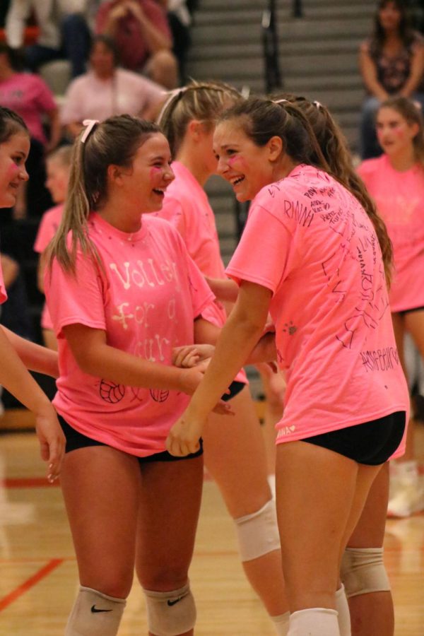 Laughing, junior Allison  Mowery and senior Evelyn Krusniak react to a missed serve. On Sept. 20, the volleyball program played the soccer program to raise money for a local cancer paitent. 