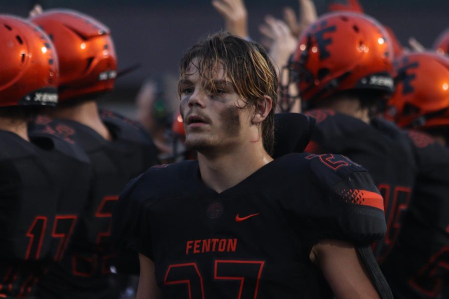 Walking the sideline, junior Philip Lamka makes his way down the field. Going against Midland Dow on Aug. 25, the Fenton Varisty football team took a victory at 46-7.