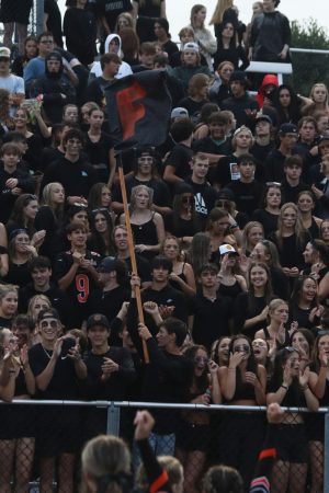 Waving the flag, the FHS sudent section dresses in black to support the Fenton varsity Tigers. The Fenton Tigers went up against Midland Dow on Aug. 25 and won 46-7. 