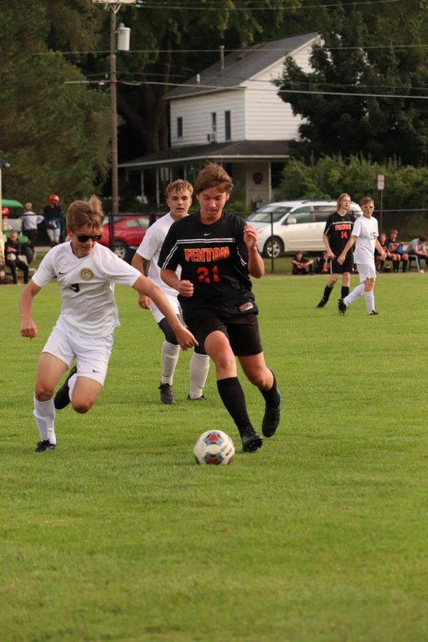 Getting around the defender, junior Zachary Kaplan dribbles the ball. On Sep. 12, the JV team beat Owosso with a score of 2-1. 