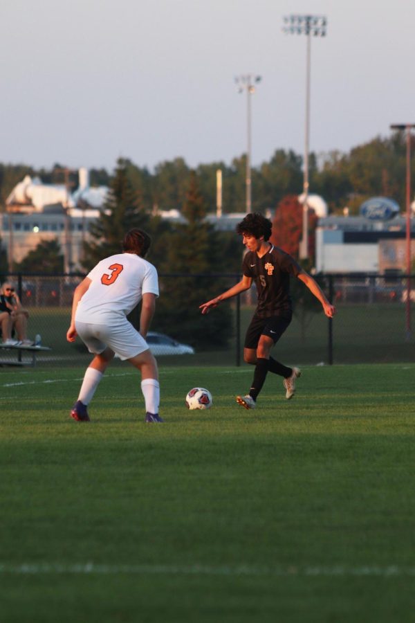 Focusing on the ball, senior Ryan Stocker goes to kick the ball. On Sep. 19, the boys varsity soccer team beat Clio with a score of 3-0. 