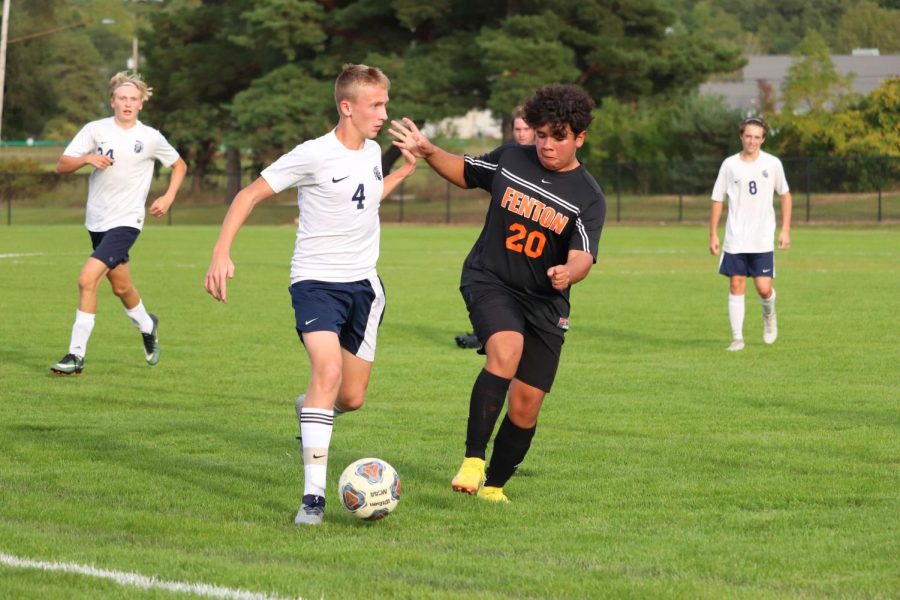 Making contact. freshman Carlos Gomez attempts to get the ball from his opponent. On Oct. 3, the JV soccer team won against the Goodrich Martians with a score of 2-0. 
