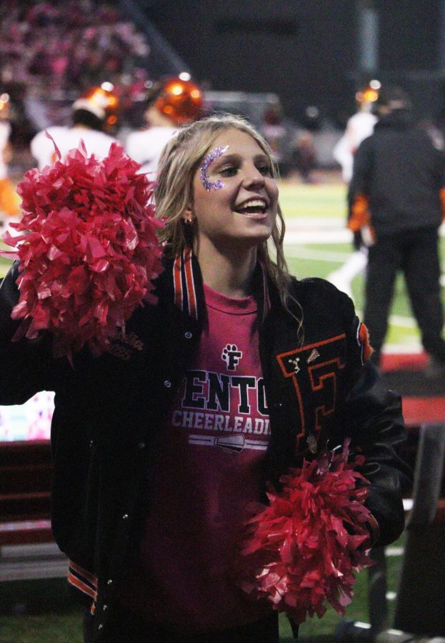 Smiling at the student section sophomore Lydia Klemish cheers. On Oct. 7 the cheer team did pink out at the Linden game.  