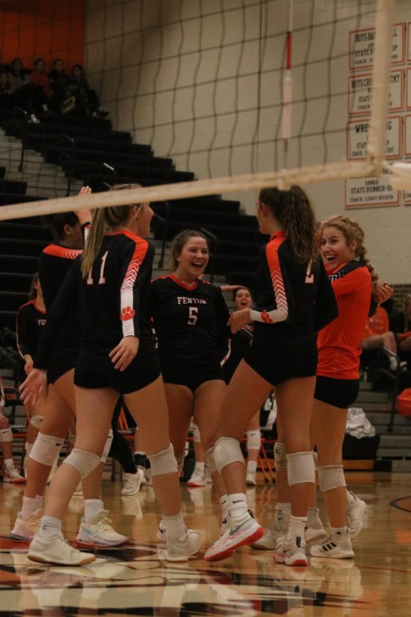 Laughing, junior Allie Mowery celebrates with her teammates. On Oct. 17, the varsity volleyball team defeated the Kearsley Hornets in all three sets. 