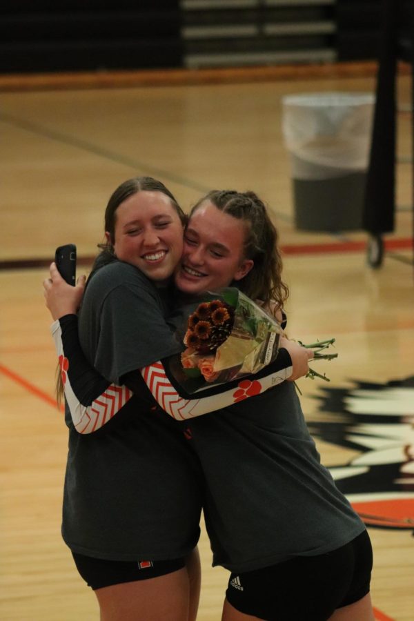 Smiling, senior Adrienne Staib and sophomore Megan Gornick hug eachother. On Oct. 17, the varsity volleyball team celebrated senior night. 