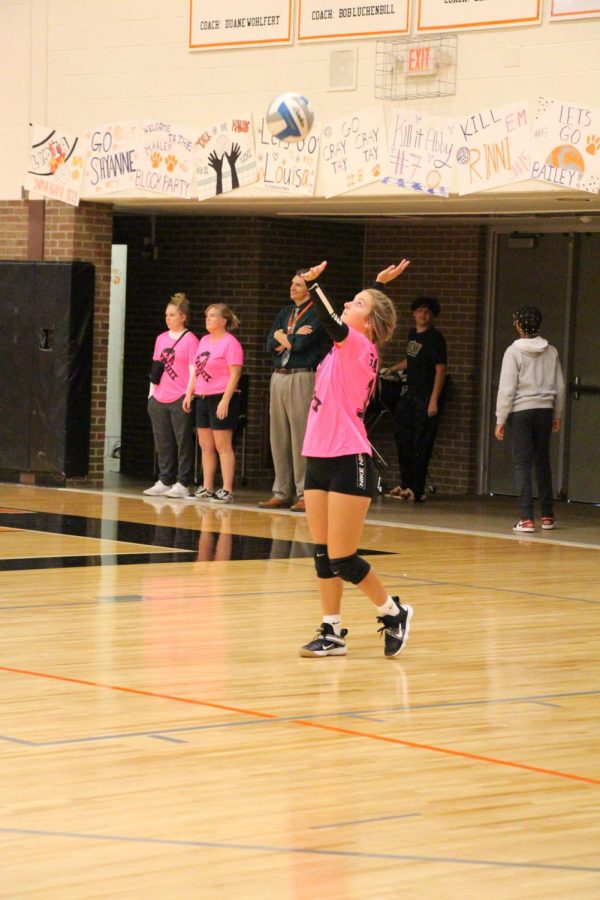 Tossing the ball in the air, freshman Bailey Britton is preparing to serve. On Oct. 5 the freshman volleyball team played against Swartz Creek, winning 3-0. The theme of the game was pink out and the girls were bringing awareness to cancer. 