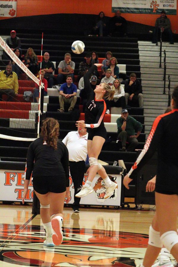 Jumping up, junior Lily Turkowski goes for a kill. On Oct. 17, the girls varsity volleyball team won all three sets against Kearsley. 
