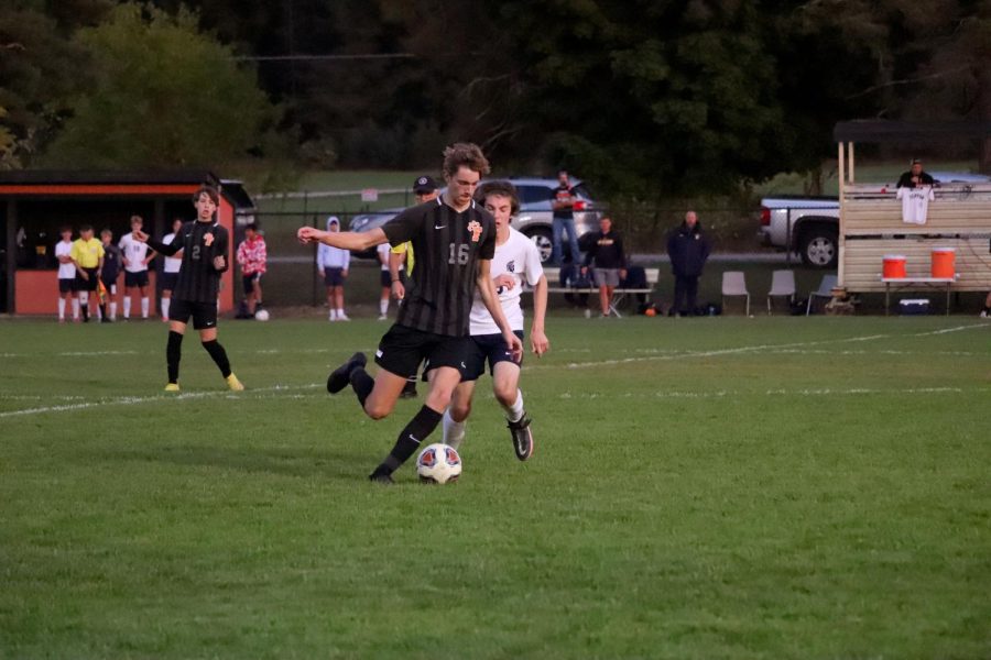 After beating his defender, junior Gibson Lehman kicks the ball. On Oct. 3, the Fenton boys varsity team took on the Goodrich Martians and lost 0-1. 