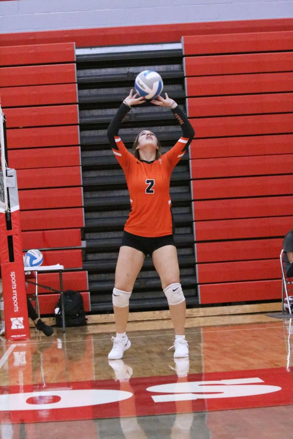 Watching the ball, sophomore Ava Slezinski sets up her teammate for a kill. On Oct. 12, the JV volleyball team faced Holly; winning all three sets. 