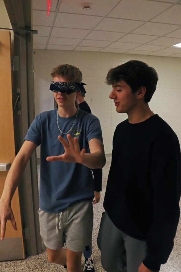 Listening to sophomore Max Wright, senior Gavin Henson gets lead blindfolded throughout the halls. On Oct. 25, FHS teacher Jill Starrs Psychology class conducted a Blind Walk experiment, leading classmates throughout the school with blindfolds. 
