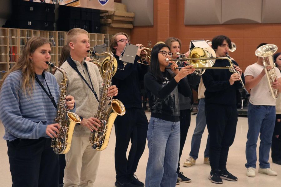 Warming up, the band prepares to perform. On Nov. 17, the marching band sent off the state swimmers by playing the fight song during their practice. 