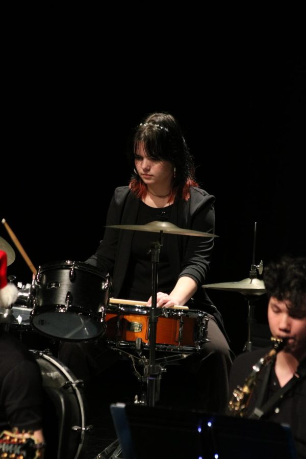 Playing the drums, junior Moira Dunlop performs with the FHS Jazz Band. On Dec. 8, the FHS bands performed in the Fenton High School auditorium for their annual holiday show. 