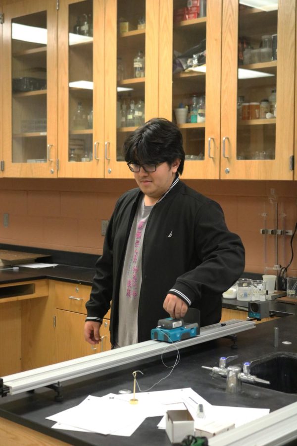 Pushing the cart, sophmore Maxwell Shaw studies friction and force. On Jan. 24, FHS science teacher Jason Kasaks classes did a lab to further their knowledge of Newtons Second Law of Motion. 