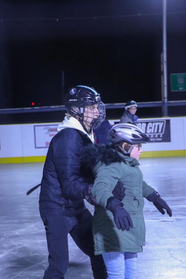 Senior, Caden Crandall helps teach kids how to skate with the Fenton Linden Area Griffins. On Dec. 7, Fentons Varsity hockey team participated at The Barns weekly learn to skate program for the Junior Griffins. 