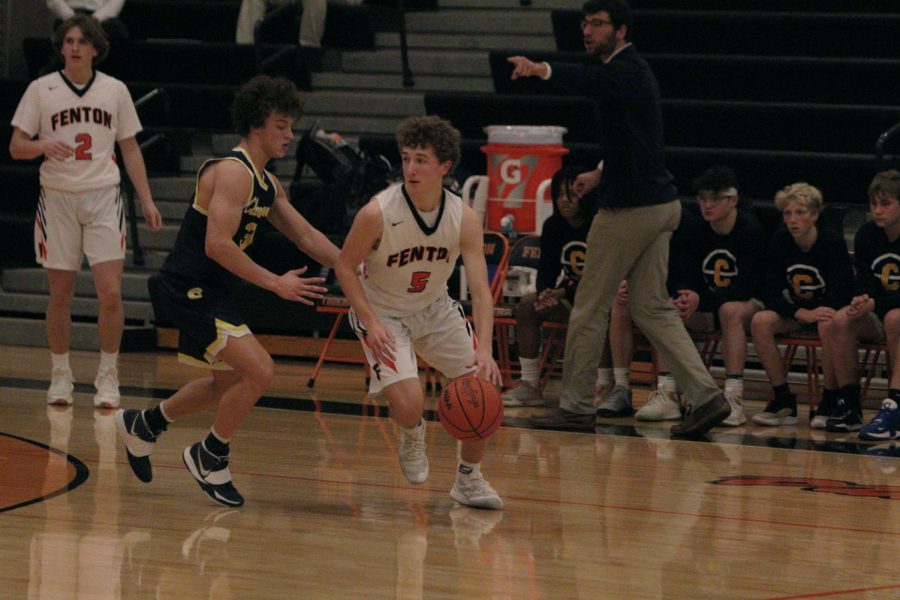 Dribbling past his opponent, sophomore Keegan Mcardle looks to make a play. On Jan. 4, the JV boys basketball team played Clarkston and lost 34-51. 