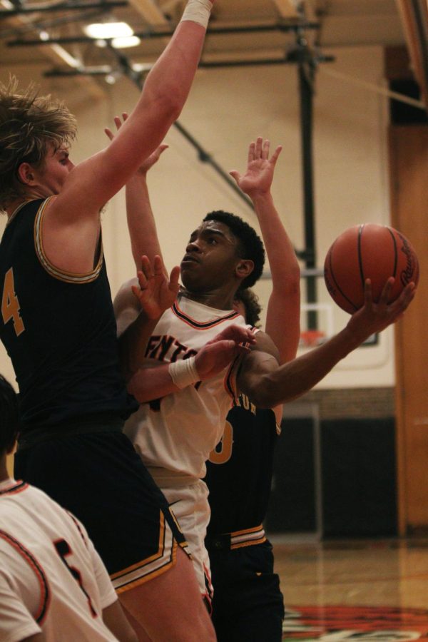 Shooting around his defenders, junior JaHion Bond goes to the basket. On Jan. 4 the Tigers lost 49-53 to Clarkston.