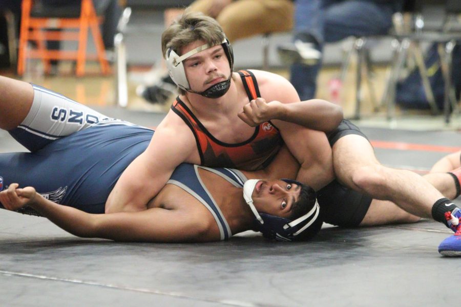 Pinning his opponent, junior Philip Lamka looks off into the crowd. The Fenton Tigers varsity wrestling team went up against mulitple opponents took 2nd place overall on Jan 21. 