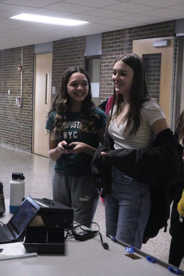 Smiling, freshman Issabell Littleton and Lily Howe buy their tickets for the winter formal. Student council was selling tickets from Jan. 23 to Jan. 31 during lunch. 