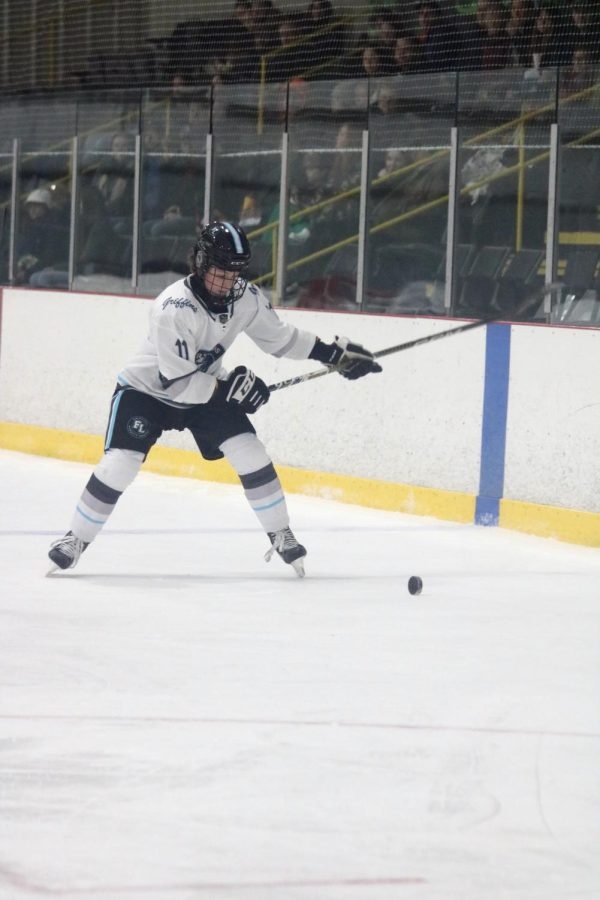Pulling back his stick, senior Jace Dumeah attempts to score a goal. On Jan. 21 the Griffins defeated Dexter 7-2. 