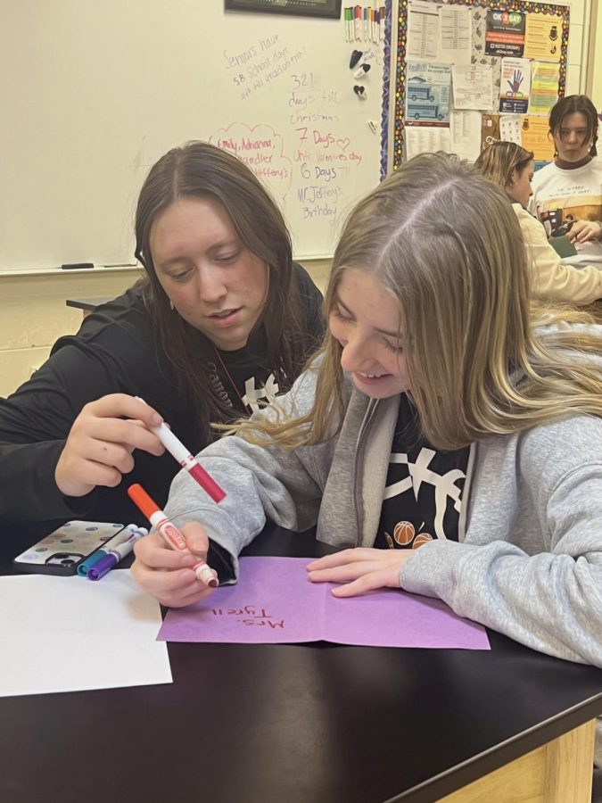 Laughing, seniors Adrienne Staib and Lauren Gadola work on a valentine. On Feb. 7, the FHS E.C.O. club created cards for the teachers for Valentines Day. 