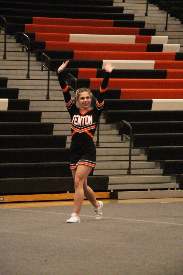 Throwing her hands in the air, junior Chloe Justus gets ready to perform. On Feb. 18 the Fenton Competitive Cheerleading team competed at districts and ended up placing 3rd. 