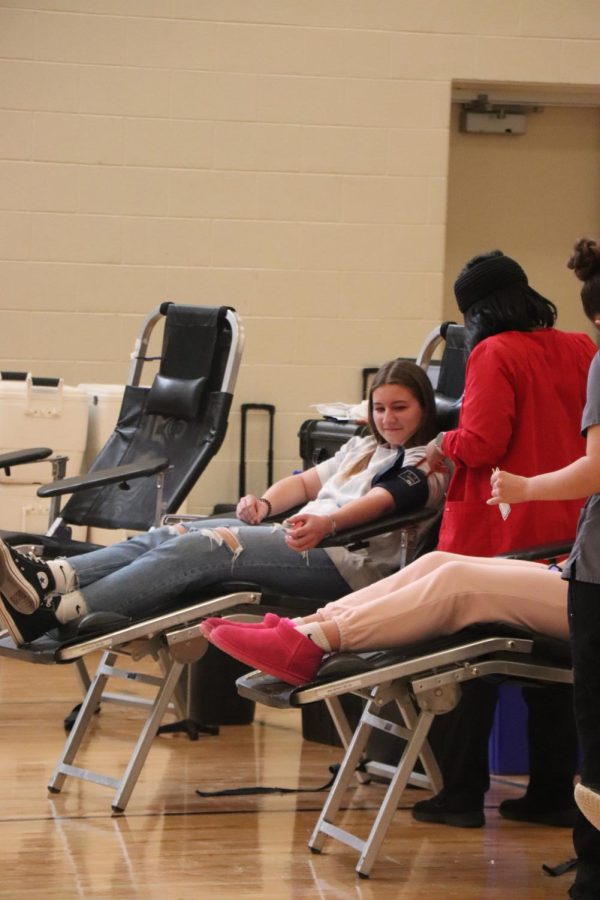 Looking down at her arm, junior Jenna Fijoleck prepares to donate blood. On Feb. 3, FHS hosted a blood drive for students and staff to donate blood. 